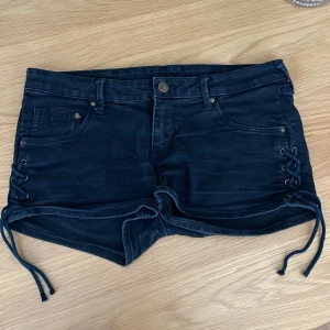 Jeansshorts från H&M - Väldigt fina svarta jeansshorts från H&M med coola detaljer på sidan, ganska stretchiga+lågmidjade. Gillar inte hur de sitter på mig💕Knappt använda och jättebra skick. Midjemåttet: 39cm rakt över💕 Längd: 23cm💕