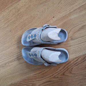 Tåsandaler med pärlor - Mycket gott skick. Vackra samdaler i beige med pärlor i turkos, blå och guld. Bekväma både på fest och till stranden.