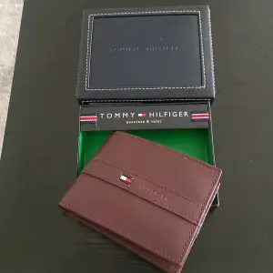 Tommy hilfiger plånbok som aldrig använts. Helt oanvänd i burgundy färg. Kommer med låda. 