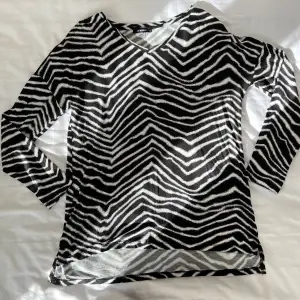 En helt vanlig zebra mönstrad tröja. Köpt på en flygplats utomlands. Har inte använt den alls så mycket. Långärmad, kall, lätt & skön inför sommaren. Längden går ner till höften. Stretchig. 