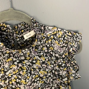 Klämning  - Jättefin mönstrad klänning. Snöre i midjan och liten volang längst ned och vid axlarna. Strykfri. Stl S men passar även M. 