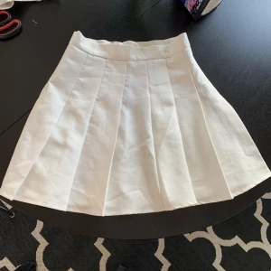 Vit tennis kjol - Vit kjol med ca 35 cm midjemått och ca 40 cm lång. Den har en liten gul fläck som knappt är synlig, men som man ser på bild två. Skriv för mer bilder eller frågor💗