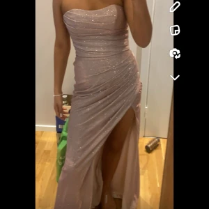 Glittrig klänning  - Klänningen är använd en gång och köptes för 3800 från affär i Södertälje. Säljer för 3000 och köper man både den här och den röda klänningen jag säljer får man båda för 3900. 