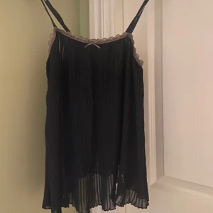 Svart topp med bruna spetskanter - Svart topp med bruna spetskanter och rosett