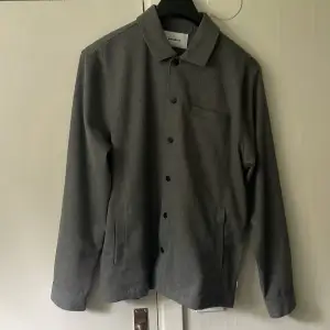 Skön snygg grå Overshirt inte för tjock, bra med plats i fickorna och perfekt under dem kyliga sommardagarna funkar nog på hösten också. Storlek Large men passar även  Medium. 10/10 skick inga defekter.