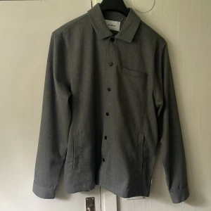 Woodbird Overshirt  - Skön snygg grå Overshirt inte för tjock, bra med plats i fickorna och perfekt under dem kyliga sommardagarna funkar nog på hösten också. Storlek Large men passar även  Medium. 10/10 skick inga defekter.