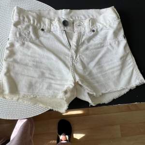 Ett par vita Dr denim shorts med en modell som framhäver rumpan på ett bra sätt.