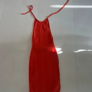 Klänning  - Cool klänning, öppen i ryggen, knyte runt halsen. Passar mig som har storlek xs/s. Färgen är en blandning av röd/orange 