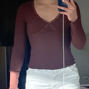 Brun V-ringad tröja med spets - V-ringad tröja med spets runt brösten, från bikbok storlek XS. Ärmarna och nedredelen av tröjan är sytt som på bild 3. Bra skick, något nopprig!⭐️