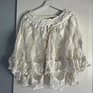 Broderad virkad poncho - Otroligt vacker poncho! Helt oanvänd med lappar kvar. Nypris 799kr