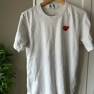 Säljer denna skit feta comme des garçons t shirt i storlek L. Men den sitter som M. Tröjan är använd och har ett litet hål som man ser på bild 3-4