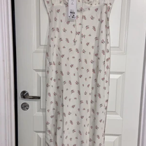 Klänning - Vit blommig klänning från Gina Tricot. Helt oanvänd, har prislappen kvar. Nypris 479kr. Frakt är inkluderat i priset