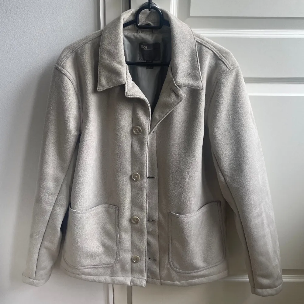 En grå/beige mocka jacka med knappar, knappt använd så den är helt hel och ren. . Jackor.