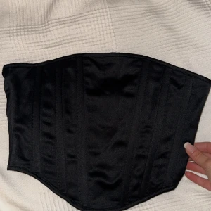 Svart korsett  - Svart korsett i satin-ish. Oanvänd storlek S.