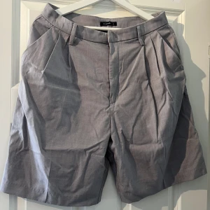 Shorts  - Gråa shorts som slutar en liten bit över knäna. Oanvända. Storlek XL - passar även L. Köparen står för ev frakt. 
