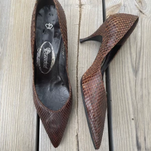 Snygga klackar av ormskinn - Bruna klackar med en spetsig tå och en smal 5cm klack. Gjort ut av äkta ornskinn. Märket är Dorndorf Storlek 5, uppskattad 37/38. Bra skick