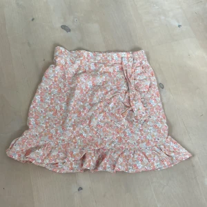 Kjol - Blommig omlottkjol från kapphals barnavdelning i tel 170(medium) fint skick då den bara har använts max 2 ggr förra sommaren. Säljer pga av att jag inte använder den.