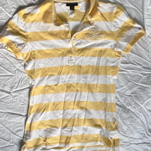 Vintage Polo - Vintage Tommy Hilfiger polo, med gul randigt mönster och korta armar. Aldrig använd.