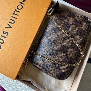 Handväska  - En äkta Louis Vuitton Mini Pochette Accessoires💕använda fint i skick , mått bredd 10 cm, länge 15 cm, DC:SF4270, made in france, köpt från Sarah page, fråga flera bilder