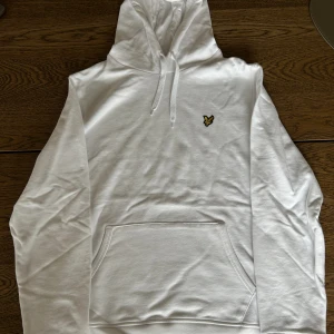 Lyle & Scott hoodie vit - En vit Lyle & Scott hoodie i storlek L. Använd en gång. Tröjan har en mycket liten fläck på framsidan, därav det billiga priset. Annats väldigt fint skick! 