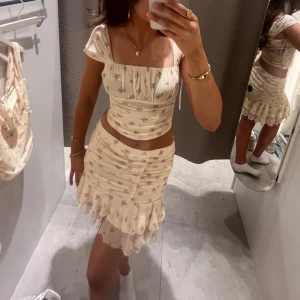 Blommigt sett  - Säljer SOMRIGASTE settet! Super söta och perfekt till midsommar! Använt endast en gång. Både kjol o top KMR me! Köpte hela settet för 800kr men säljer båda för 500!