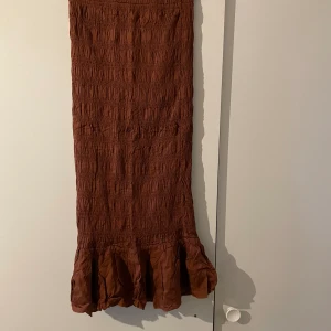 Midikjol från Gina Tricot - OANVÄND! Nyskick brun midikjol från Gina tricot! Storlek S/34