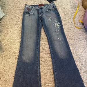 Utsvängda lowwaist jeans. De har jätte coolt blom mönster i paljetter på höger ben. De har även andra coola detaljer på fickorna och bakbenen och en snygg tvätt. Det ända felet är att dragkedjan är trasig, men det syns inte när man har på sig dem❤️