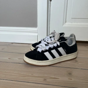Adidas Campus 00s - Svarta Adidas Campus i strl 40. Använda i ca 2 månader men hyfsat bra skick, se bilderna! Svarta helt oanvända snören medföljer. Skriv vid funderingar💓