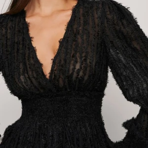 Blus med fransar och smock  - Jättefin svart blus som går att matcha med allt! Använd endast en gång.