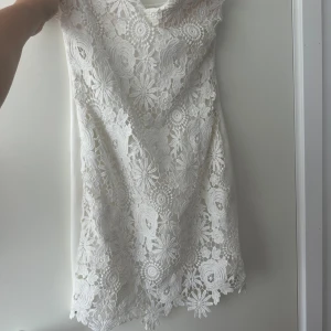 Klänning - Jättefin vit blommig klänning som passar perfekt till studenten!  Aldrig använd så är i nyskick.