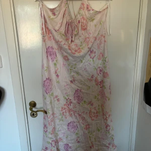 Blommig klänning  - Lång blommig klänning i silkes liknande tyg som kurvan kroppen väldigt fint 🥰 strl 48 på lappen men mer som 52/54