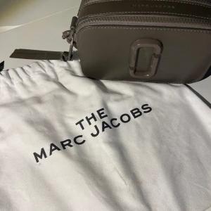 Marc Jacobs väska  - Militärgrön marc Jacobs väska i modellen snapshot som är super fin men tyvärr inte kommer till användning. Bra skick men lite färg har skavts bort från spännen på sidorna men det syns knappt. Skriv gärna om du vill veta något mer!💕💕