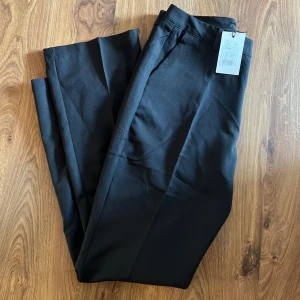 Svarta byxor  - Jag säljer mina oanvända, svarta, ”Vilma” byxor från bikbok, då jag beställde hem två par av samma byxa.  Prislappen är fortfarande på. Storlek 44. Supersköna kostymbyxor! 