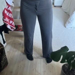 Gråa kostymbyxor - straight fit. ett spänne som saknar ögla i midjan. men finns kedja att spänna med istället så funkar bra ändå.