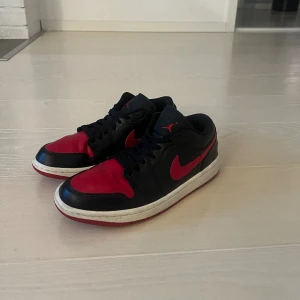 Röd/svarta Jordans 1 low - Hej, jag säljer mina Jordans som jag köpte från förra året. Dom har inte används så många gånger så dom är i fint skick. Storlek 38,5