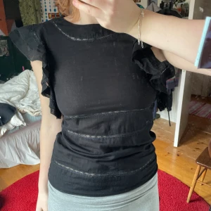 Svart topp - Så söt topp med bolanger och andra detaljer! Sitter fint och passar med allt verkligen🩷bra skick! Meddela vid funderingar☺️