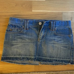 Kort jeanskjol - Ursnygg jeanskjol från abercrombie med slitningar nertill. Perfekt längd och blå färg💕