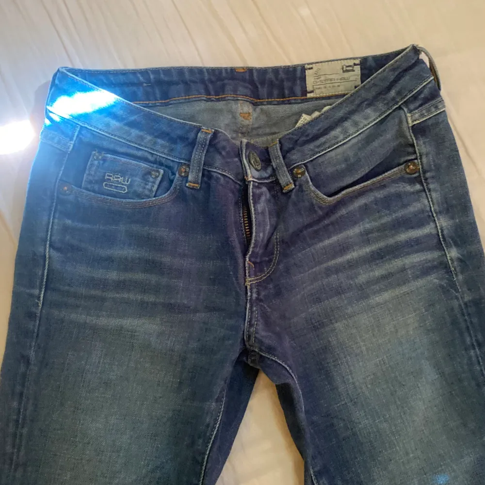 Säljer nu ett par jätte fina mörkblå G-jeans med två fina embroderier bak och fram. Byxorna är mid/lowrise och är i storlek w25l32💞. Jeans & Byxor.