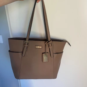 Handväska - Brun handväska med dragkedjeficka och fack. Använd men i fint skick från new york portable design