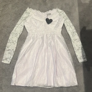 Vit klänning - Klänningen är helt ny från Bubbelroom, aldrig använd. Kjolen hade ingen spets men en sömmerska har sytt på spets på kjolen. Den är i bra skick och jättefin på. Pris kan diskuteras 
