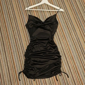 Festklänning  - En blandsvart klänning. Den har band på varje sida som man kan dra upp eller ner för att ända längden på den lite. Klänningen är storlek S men jag är storlek M som kan vara bra att veta.