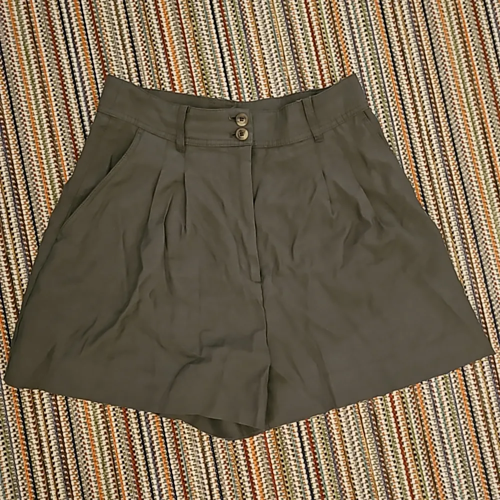 Mititärgröna shorts med hög midja som är breda vid låren. . Shorts.