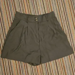 Mititärgröna shorts med hög midja som är breda vid låren. 