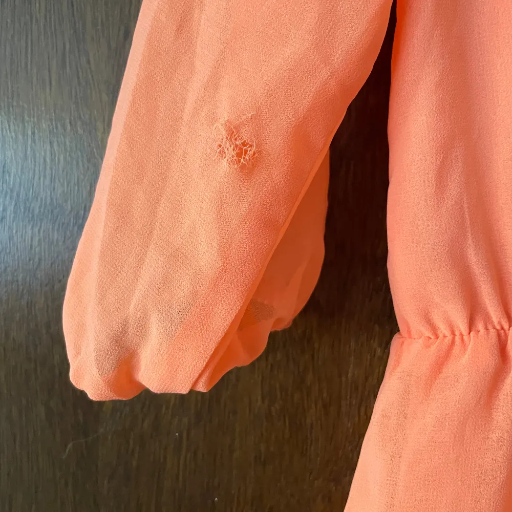 Fin orange klänning från Bik bok med öppen rygg och kedja. Använd 1 gång, fastnade tyvärr i en rosbuske och blev en reva ”hål” i ena armen ( se bild), storlek M.. Klänningar.