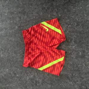 Nike träning shorts i extremt fint skick. Skick:10/10. Storlek: M. Färg röd och gul. 