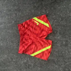 Nike träning shorts i extremt fint skick. Skick:10/10. Storlek: M. Färg röd och gul. 