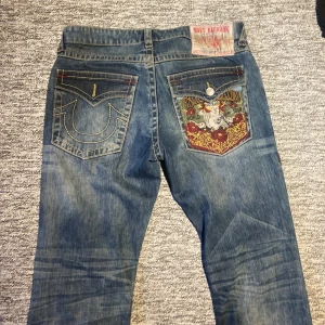 True religion jeans - Skit snygga true religion jeans med cool design på högra bakfickan Baggy passform Gylfknappen ramla av men funkar helt perfekt med bälte eller så kan man sätta på en nu👌 Självfallet går det sänka priset