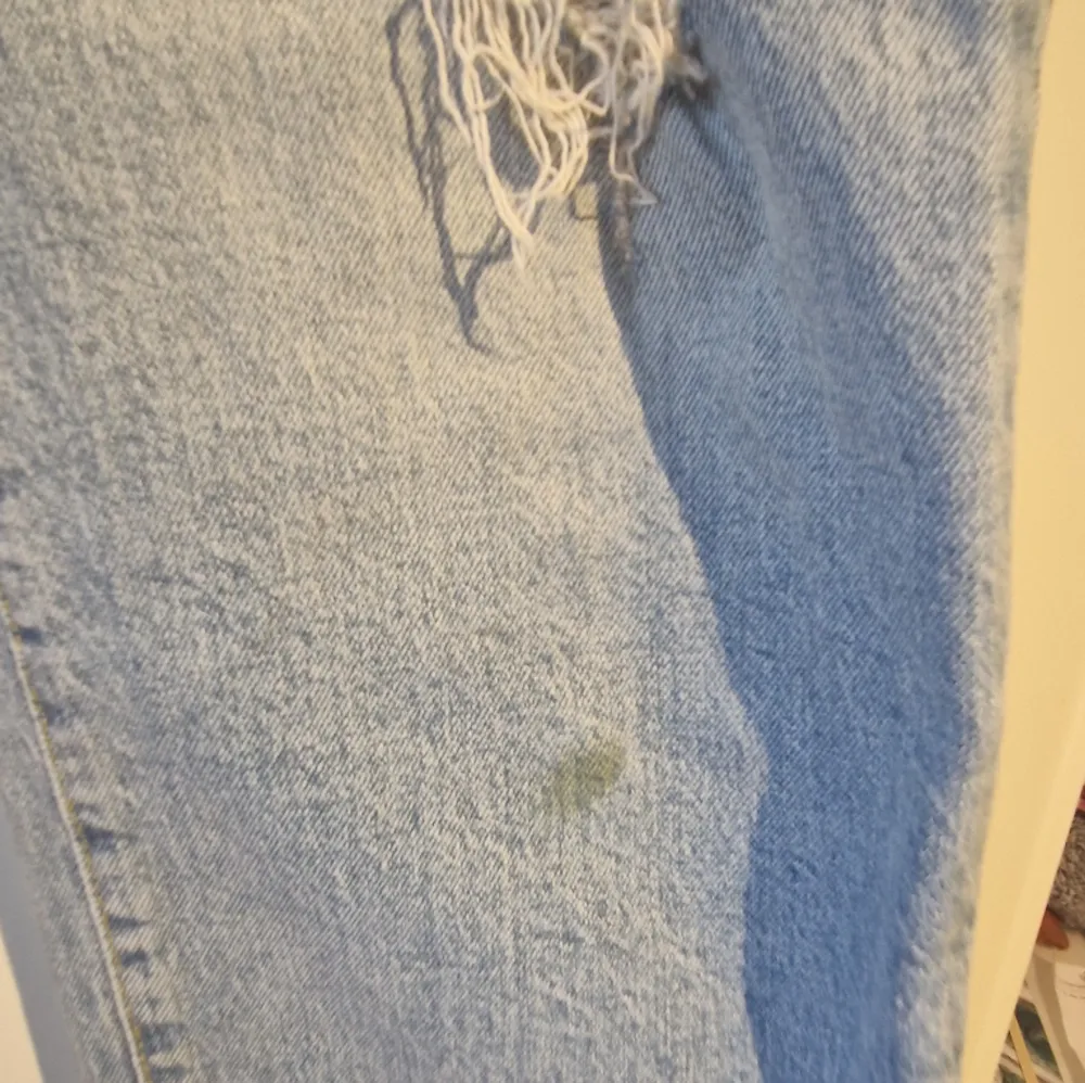 Ett par raka ljusblå jeans från hm med hål på knät. De har en lite gräsfläck på ena benet den kanse går att tvätta bort. Har bara använt dem ett fåtal gånger . Jeans & Byxor.