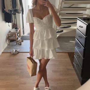 Studentklänning  - Super fin studentklänning med volanger, st 34. Använd endast en gång och är fortfarande i nyskick.