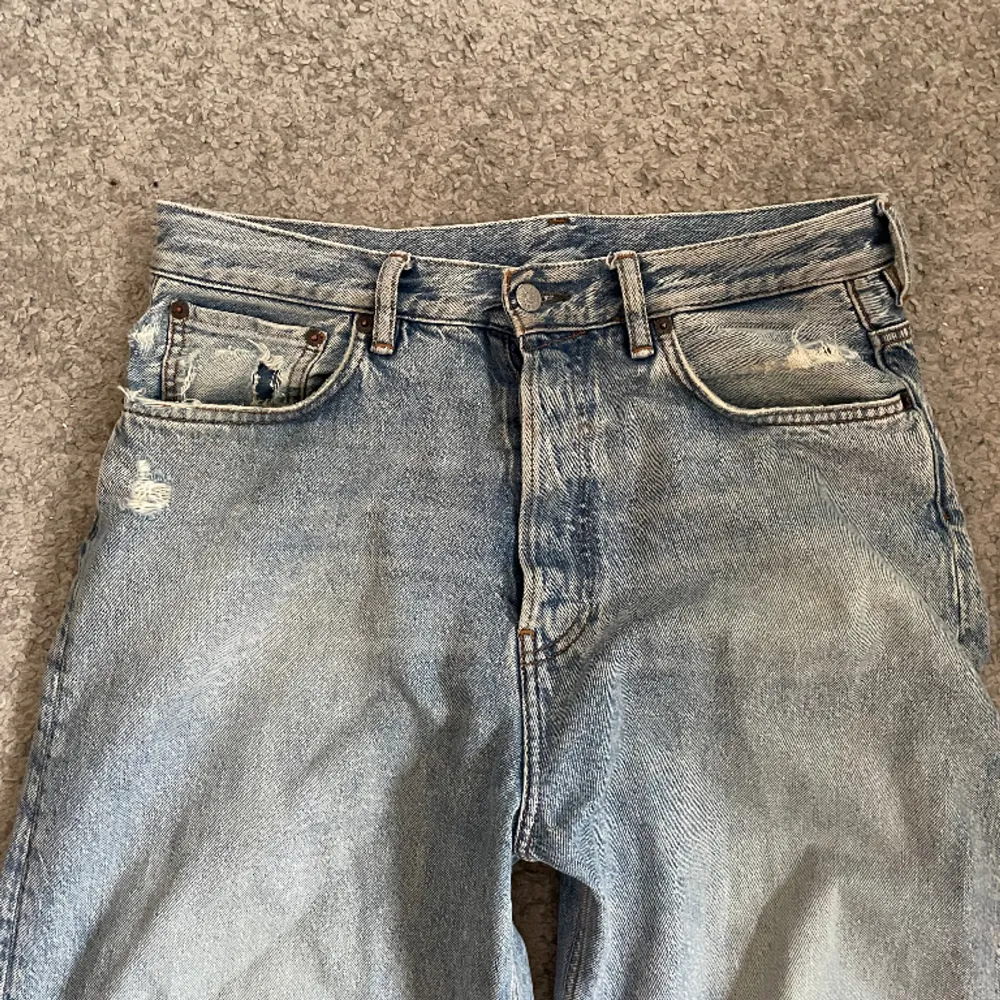 Ett par baggy jeans från acne studios Använt skick Sönder vid ben öppning Stl 29/30 Waist:40cm Length:103cm. Jeans & Byxor.